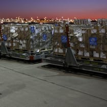  A Dubai Humanitarian staff stands in front of pallets of aid for Gaza at the Royal Airwing airport before dispatching, in Dubai, United Arab Emirates, January 24, 2025.