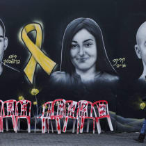  Una persona pasa junto a un mural que representa a los rehenes israelíes Rom Braslavski, Karina Ariev y Eitan Mor (I-D), secuestrados en el mortífero atentado perpetrado por Hamás el 7 de octubre de 2023, en Jerusalén, el 23 de enero de 2025.
