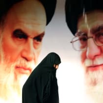  Una mujer pasa junto a un cartel en el que aparecen el líder supremo de Irán, el ayatolá Ali Jamenei, y el fundador de la República Islámica, el ayatolá Ruhollah Jomeini.