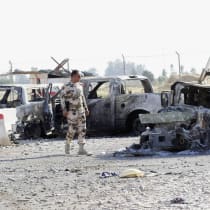  A member of the Kurdish security forces looks at the wreckage of a vehicle belonging to Iraqi security forces in the outskirts of Kirkuk June 16, 2014. 