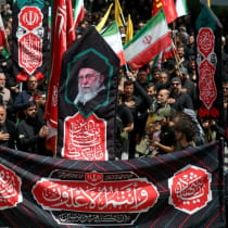 Iraníes portan una pancarta con las imágenes del líder supremo, el ayatolá Alí Jamenei, durante una concentración en su apoyo, mientras los musulmanes chiíes asisten al ritual de luto "Tasua" (noveno día) para conmemorar el martirio del nieto del profeta Mahoma, el imán Husein. 