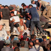 Palestinos suben a un camión en busca de suministros de ayuda en Khan Younis, sur de la Franja de Gaza, 4 de agosto de 2025. 
