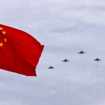 Shenyang J-16, Chengdu J-20 and Shenyang J-35 fighter jets fly in a formation past a Chinese national flag during a flyover rehearsal ahead of a military parade to mark the 80th anniversary of the end of World War Two, in Beijing, China, August 24, 2025. 