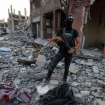 Un terrorista palestino de Hamás junto a restos humanos cubiertos entre los escombros, después de que Hamás anunciara el martes que había encontrado el cadáver de un soldado israelí secuestrado y se preparara para devolverlo a Israel a través de la Cruz Roja, en la ciudad de Gaza, el 4 de noviembre 