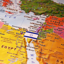 An illustrative image of an Israeli flag on top of a map of the Levant region of the Middle East.