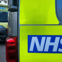 The NHS logo is displayed on a ambulance parked close to a nearby hospital, on October 20, 2025.