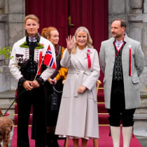 La princesa heredera de Noruega, Mette-Marit, saluda con la mano mientras, junto con el príncipe heredero Haakon y el príncipe Sverre Magnus, recibe a la comitiva infantil con motivo de la Fiesta Nacional de Noruega, en Asker (Noruega), el 17 de mayo de 2026.