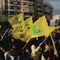 Varias personas sostienen banderas de Hezbolá mientras conmemoran la retirada de Israel del sur del Líbano en 2000, en los barrios del sur de Beirut, Líbano, el 25 de mayo de 2026. 