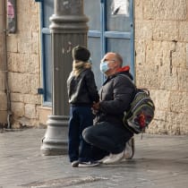 A father talking to his son on a winter morning in Jaffa street, both wearing protective masks, Jerusalem, November 5th, 2020