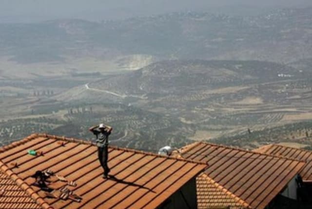 jewish settlers stands on a house Homesh in 2005 370 (photo credit: REUTERS)