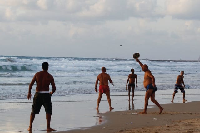 Beach-goers play paddleball in Tel Aviv. (photo credit: REUTERS)
