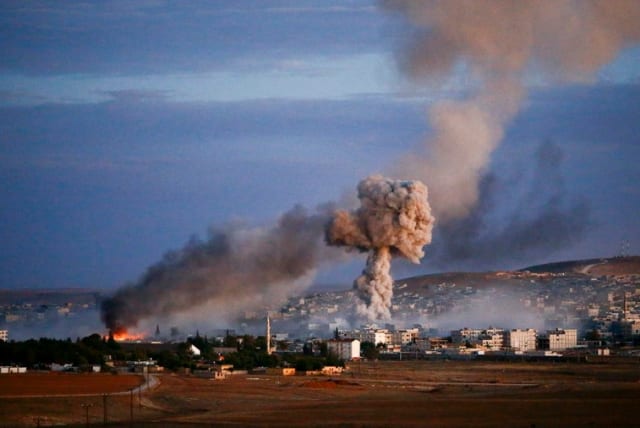 Smoke and flames rise over the Syrian border town of Kobani after an airstrike, October 20, 2014 (photo credit: REUTERS)