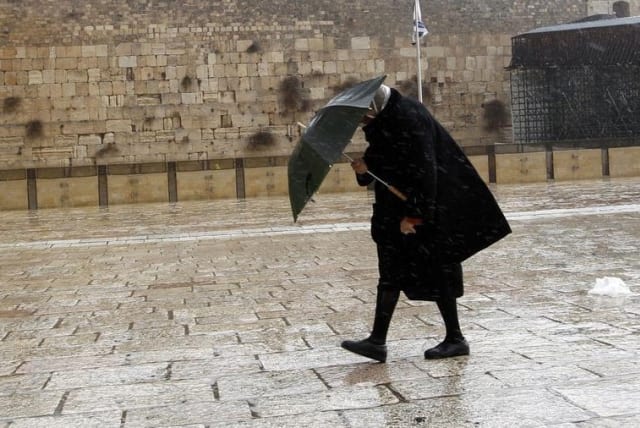 A woman walks in front of the Western Wall in Jerusalem (photo credit: REUTERS)