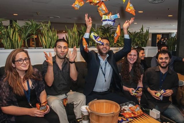 STUDENTS AT the Israeli-American Council’s Mishelanu National Conference in Los Angeles enjoy Israeli snacks Bamba and Bisli on Saturday (photo credit: RANI SIKOLSKY/IAC)