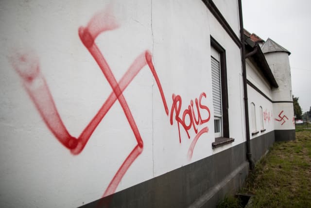 Swastika and the word "Raus" (Out) are sprayed at a asylum seeker accommodation in Waltrop, western Germany, on October 13, 2015. (photo credit: AFP PHOTO)