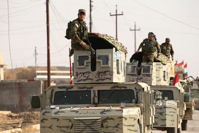 PESHMERGA FORCES ride on military vehicles in the town of Bashiqa, after it was recaptured from the Islamic State, east of Mosul, last year. (photo credit: REUTERS)