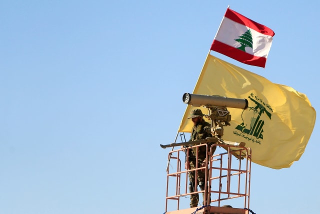 A Hezbollah fighter stands at a watch tower at Juroud Arsal, the Syria-Lebanon border (photo credit: REUTERS)
