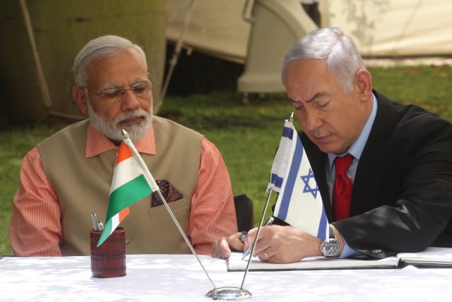 PRIME MINISTER of India Narendra Modi looks on during his 2017 visit to Israel as Prime Minister Benjamin Netanyahu signs a document of cooperation. (photo credit: MARC ISRAEL SELLEM/THE JERUSALEM POST)