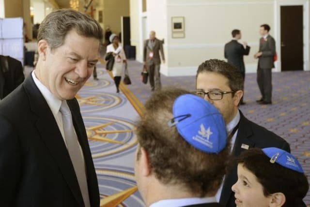 Then-Kansas Gov. Sam Brownback chats with a group from the Young Jewish Conservatives at the Conservative Political Action Conference in Maryland in 2015 (photo credit: MIKE THEILER/REUTERS)