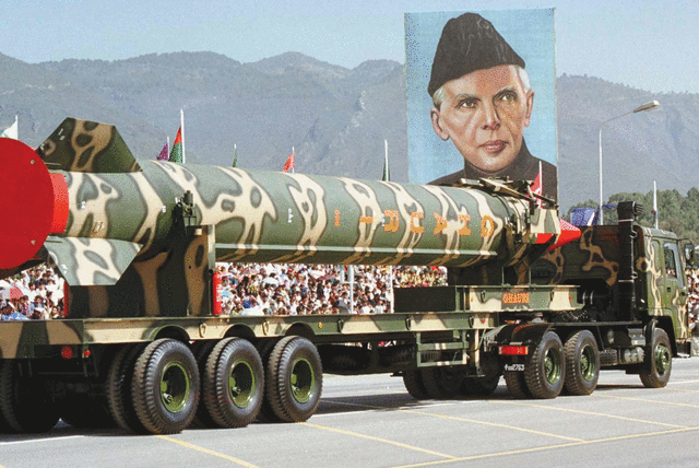 A PAKISTAN ARMY vehicle carrying the long-range surface-to-surface Ghauri missile passes a portrait of the nation’s founder, Muhammad Ali Jinnah, in 1999. (photo credit: REUTERS)