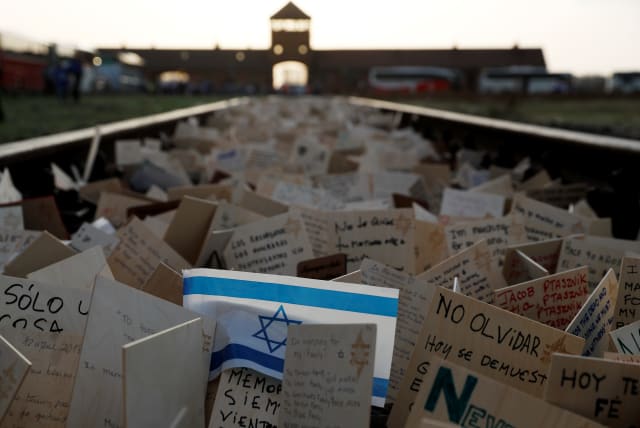 Cards are placed between railway tracks in the former Nazi death camp Auschwitz as people take part in the annual "March of the Living" to commemorate the Holocaust, in Oswiecim, Poland, April 12, 2018.  (photo credit: REUTERS/KACPER PEMPEL)
