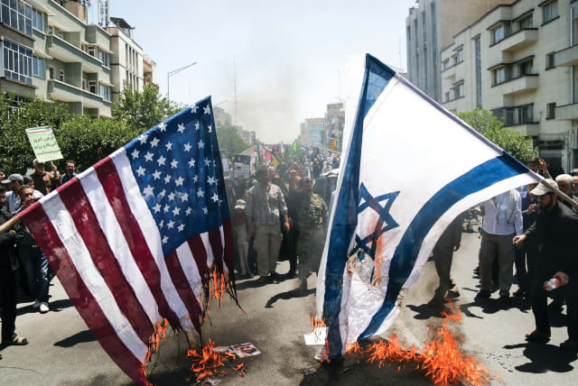 IRANIANS BURN US and Israeli flags during a protest in Tehran in June (photo credit: TASNIM NEWS AGENCY/HANDOUT VIA REUTERS)