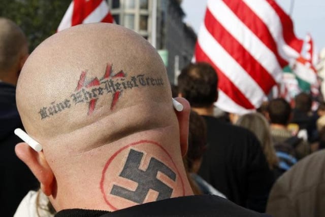 A neo Nazi attends a rally in Budapest October 23, 2009. The words, the motto of the S.S., read "my honor is my loyalty" (photo credit: LASZIO BALOGH/REUTERS)