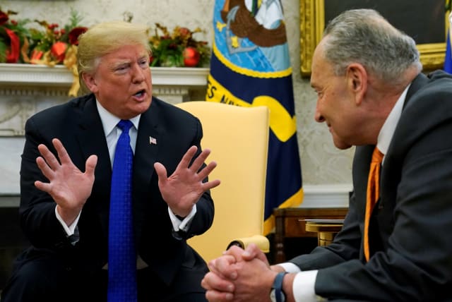 U.S. President Donald Trump speaks to Senate Minority Leader Chuck Schumer (D-NY) during a meeting with the House and Senate Democratic leadership in the Oval Office of the White House in Washington, U.S., December 11, 2018 (photo credit: KEVIN LAMARQUE/REUTERS)