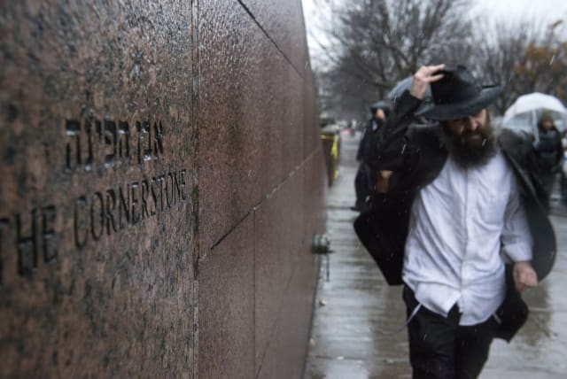 A man walks past the world headquarters of the Chabad-Lubavitch movement, the scene of a stabbing at the Brooklyn synagogue in New York City December 9, 2014. New York police shot and killed a man armed with a knife early Tuesday after he stabbed a rabbinical student from Israel in the head in a Bro (photo credit: STEPHANIE KEITH/REUTERS)