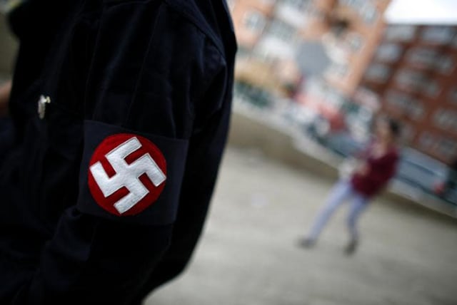 A man wearing a Swastika [Illustrative] (photo credit: CARLOS BARRIA / REUTERS)