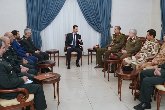 President Bashar al-Assad (C) meeting with Iraq's Chief of Staff Othman al-Ghanimi (4th-R) and Iran's Chief of Staff Mohammad Hossein Bagheri (5th-L) in the presence of Syrian Defence Minister Ali Abdullah Ayyoub (3rd-R) in the Syrian capital Damascus  (photo credit: SANA/AFP)