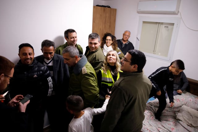 Residents and security personnel gather in a bomb shelter inside a house that was hit earlier, as air-raid siren goes off for incoming rockets from Gaza, in Sderot, Israel March 25, 2019 (photo credit: AMIR COHEN/REUTERS)