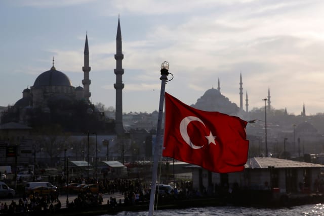 A Turkish flag, with the New and the Suleymaniye mosques in the background, flies on a passenger ferry in Istanbul, Turkey, April 11, 2019. (photo credit: MURAD SEZER/REUTERS)