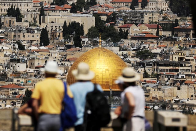 Tourists look at the Dome of the Rock, located in Jerusalem's Old City on the compound known to Muslims as Noble Sanctuary and to Jews as Temple Mount (photo credit: REUTERS/AMMAR AWAD)