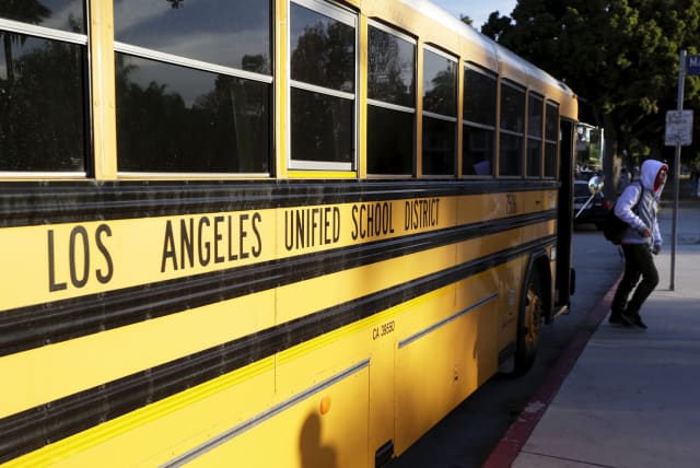 A student exits a bus as he arrives at Venice High School in Los Angeles, California (photo credit: JONATHAN ALCORN/REUTERS)