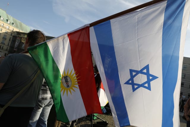 Protesters hold Kurdish and Israeli flags during a rally against the Turkish military operation in Syria, in Berlin, Germany, October 14, 2019 (photo credit: MICHELE TANTUSSI/REUTERS)