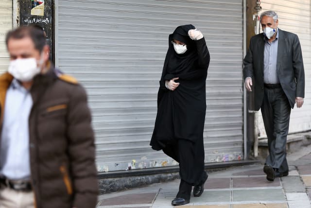 Iranian people wear protective masks to prevent contracting a coronavirus, in Tehran, Iran February 29, 2020 (photo credit: REUTERS)