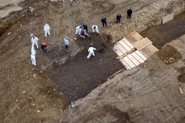 Drone pictures show bodies being buried on New York's Hart Island where the department of corrections is dealing with more burials overall, amid the coronavirus disease (COVID-19) outbreak in New York City, U.S., April 9, 2020. (photo credit: LUCAS JACKSON / REUTERS)