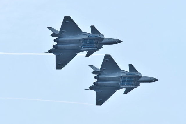 Chengdu J-20 stealth fighter jets of Chinese People's Liberation Army (PLA) Air Force perform with open weapon bays during the China International Aviation and Aerospace Exhibition, or Zhuhai Airshow, in Zhuhai, Guangdong province, China November 11, 2018. (photo credit: STRINGER/ REUTERS)