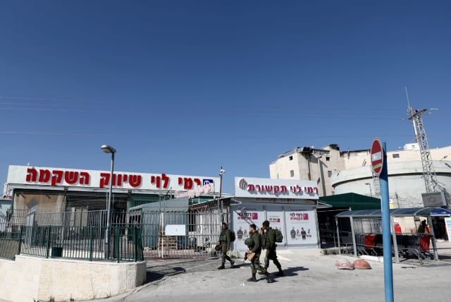 Israeli soldiers walk past Rami Levy chain store in the Israeli Sha'ar Binyamin Industrial Zone in the West Bank (photo credit: REUTERS/AMMAR AWAD)