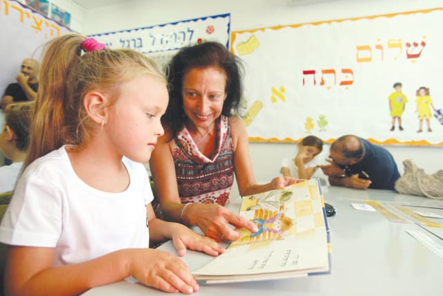 PARENTS AND pupils read together in a first grade class at Paula Ben-Gurion School in Jerusalem.  (photo credit: YOSSI ZAMIR/FLASH90)