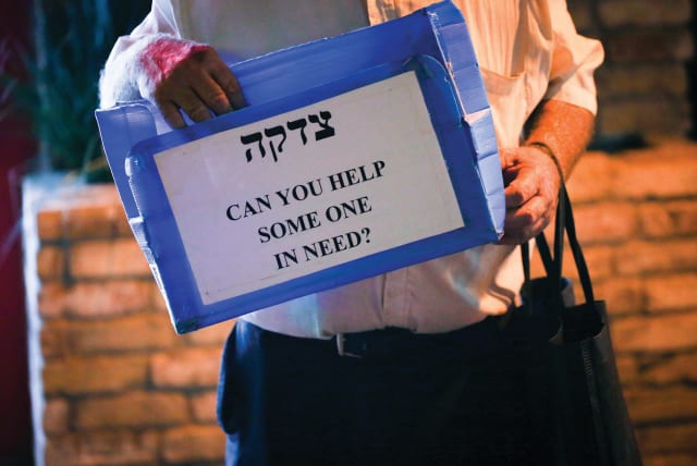 THE BEST way to fight the pandemic is to pass on kindness: to give tzedaka to those who have lost their jobs, to help elderly people who cannot go out to shop, to make a shiva minyan in a park opposite a mourner’s house (photo credit: DAVID COHEN/FLASH 90)