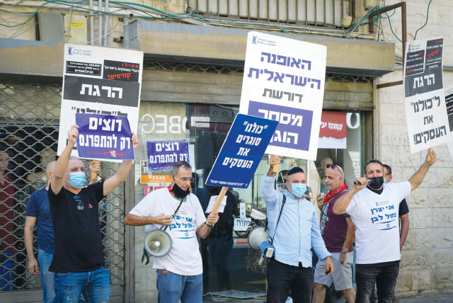 BUSINESS OWNERS in Tel Aviv protest the ongoing nationwide closure, on Monday. (photo credit: AVSHALOM SASSONI/FLASH90)
