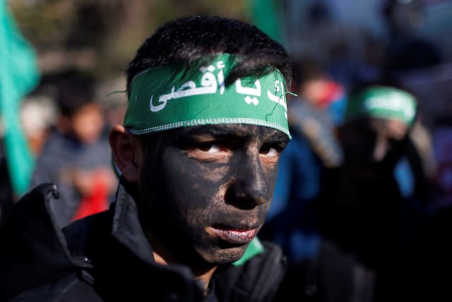 A young Palestinian has his face painted as he looks on during a Hamas rally in Gaza January 3, 2020 (photo credit: REUTERS/MOHAMMED SALEM)