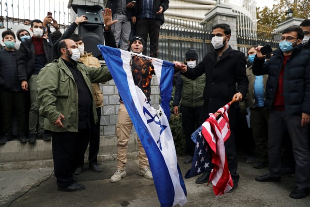  Protesters burn the US and Israeli flags during a demonstration against the the killing of Mohsen Fakhrizadeh, Iran's top nuclear scientist, in Tehran, Iran, November 28, 2020. (photo credit: MAJID ASGARIPOUR/WANA (WEST ASIA NEWS AGENCY) VIA REUTERS)