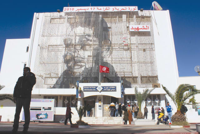 A PICTURE OF Mohamed Bouazizi, the street vendor whose self-immolation 10 years ago signaled the start of the so-called Arab Spring, is displayed on the post office building in Sidi Bouzid, Tunisia, on December 8. (photo credit: REUTERS/ANGUS MCDOWALL)