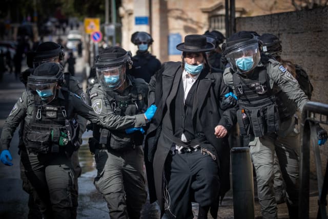 Israeli police officers clash with ultra-Orthodox Jewish men during enforcement of coronavirus emergency regulations, Jerusalem, January 26, 2021 (photo credit: YONATAN SINDEL/FLASH90)