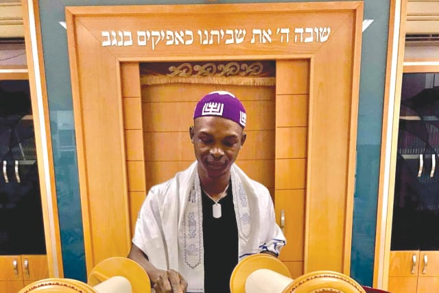 YOSEF KIBITA reading from the Torah in the synagogue at Kibbutz Ketura, his adopted home for the last three years. (photo credit: Courtesy)