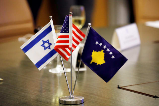 The flags of Israel, Kosovo and the US are seen on a desk during a virtual ceremony to sign an agreement establishing diplomatic relations between Israel and Kosovo in the Israeli foreign ministry in Jerusalem February 1, 2021 (photo credit: REUTERS/AMIR COHEN)