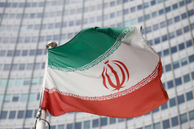 The Iranian flag waves in front of the International Atomic Energy Agency (IAEA) headquarters, before the beginning of a board of governors meeting, amid the coronavirus disease (COVID-19) outbreak in Vienna, Austria, March 1, 2021. (photo credit: REUTERS/LISI NIESNER/FILE PHOTO)